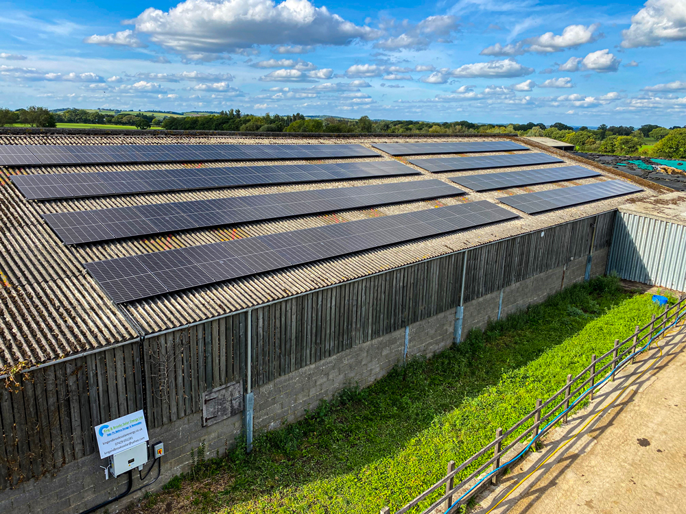 Array of commercial solar PV panels mounted to pitched roof geenrating renewable energy.