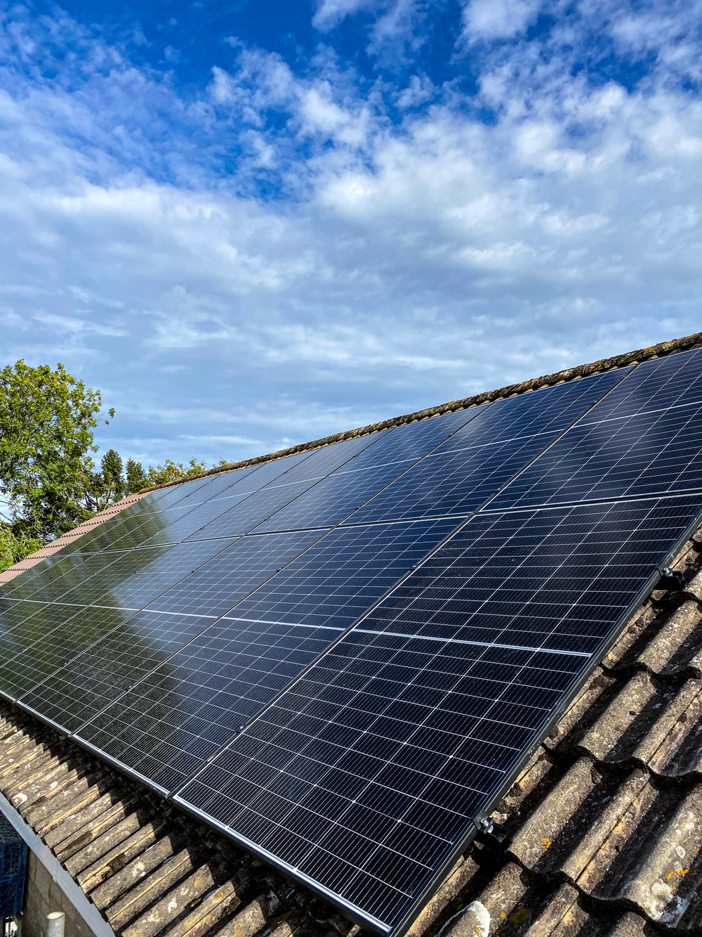 Large domestic Solar PV renewable pitched solar panel mounted to pitched roof generating energy