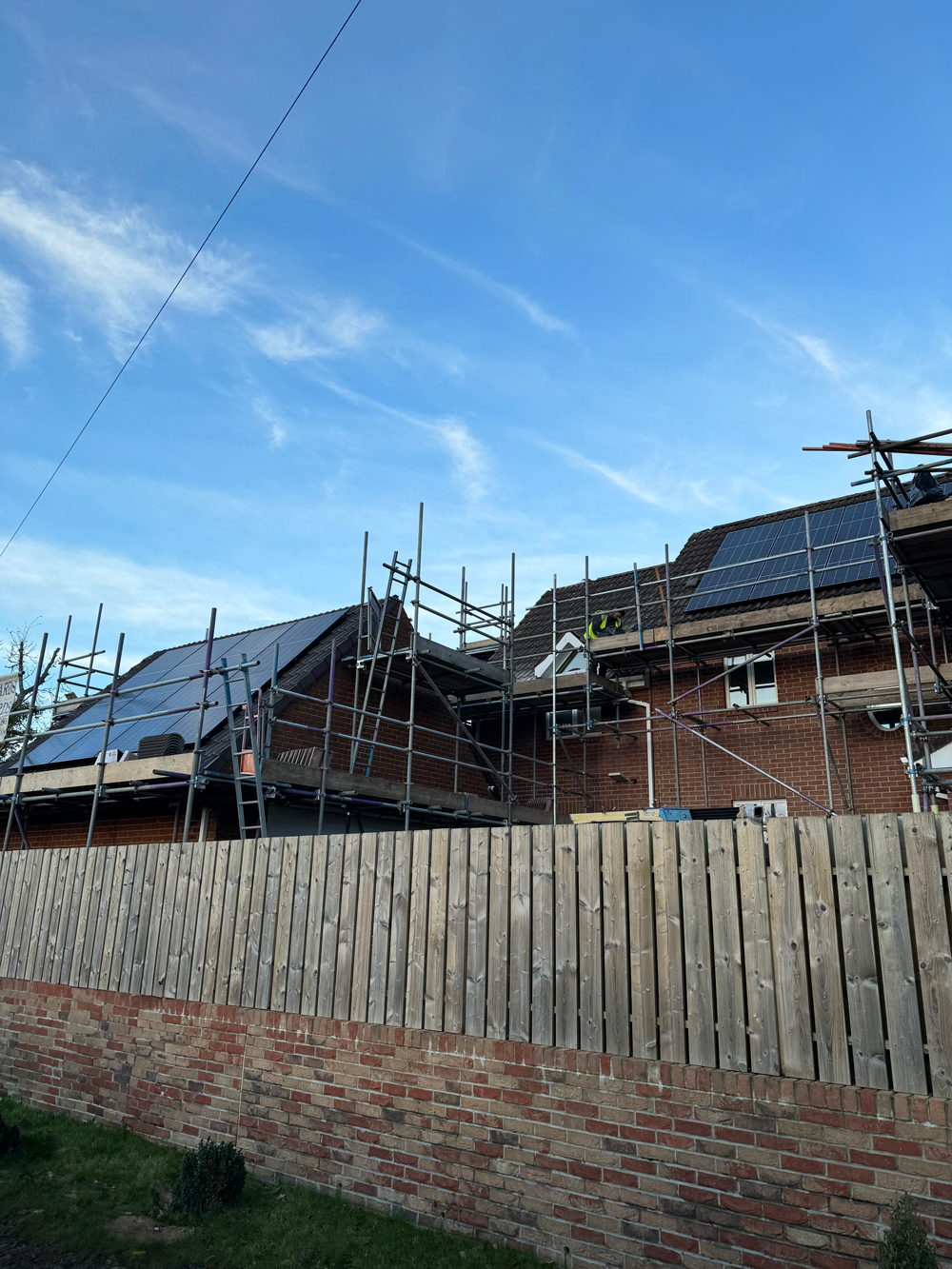 pv solar panels being installed on new house outside with scaffolding
