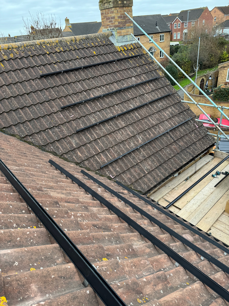 Solar panel installation at home roof hooks mounted to pitched roof
