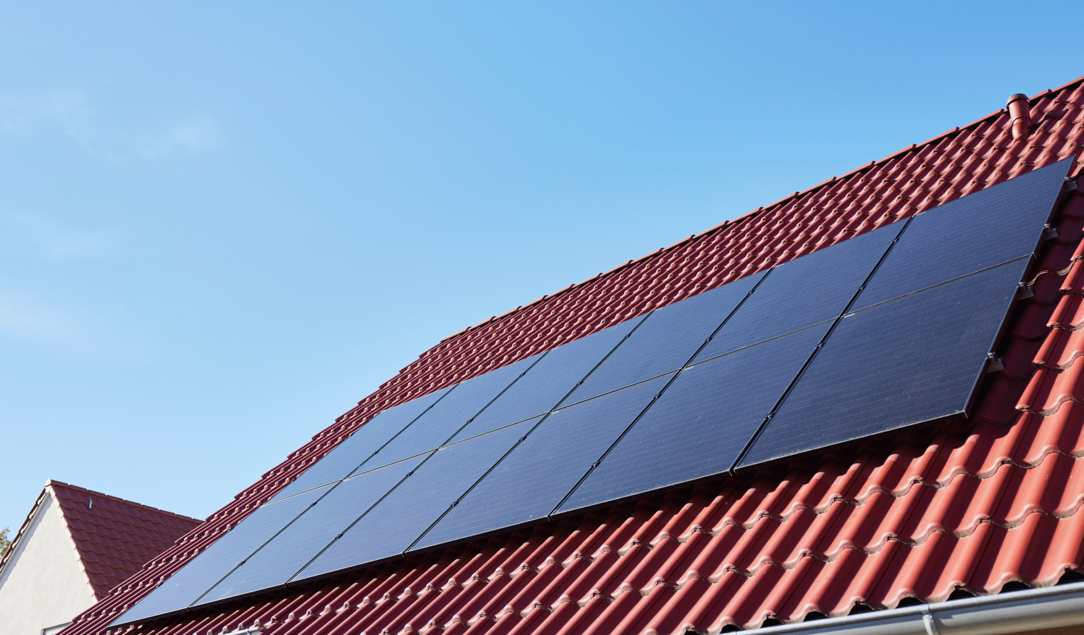 Solar panels on roof with blue sky